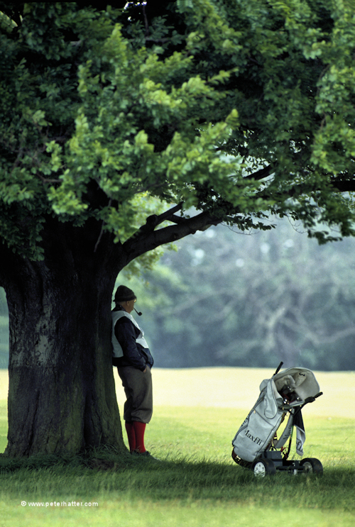 Sports photography example of golf caddy sheltering.